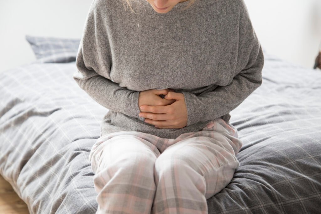 Photo d'une femme qui se tien le ventre car elle à des douleurs gynecologiques
